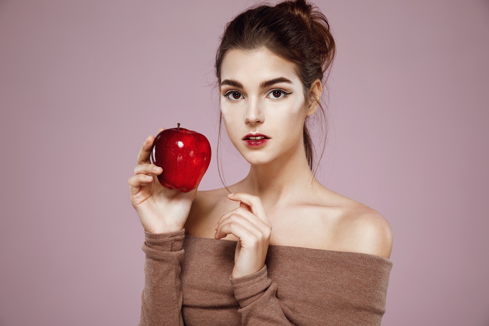 Endulzamiento con manzana: mujer con una manzana en su mano derecha.