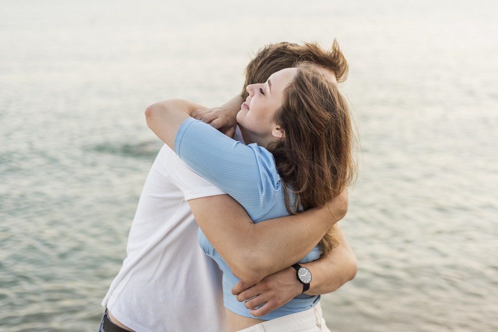 Pareja feliz se abraza /ambos cuentan sus testimonios de amarres de amor
